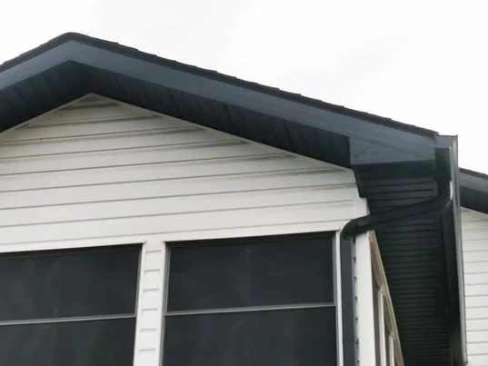 Black eavestrough and downspout on a white home