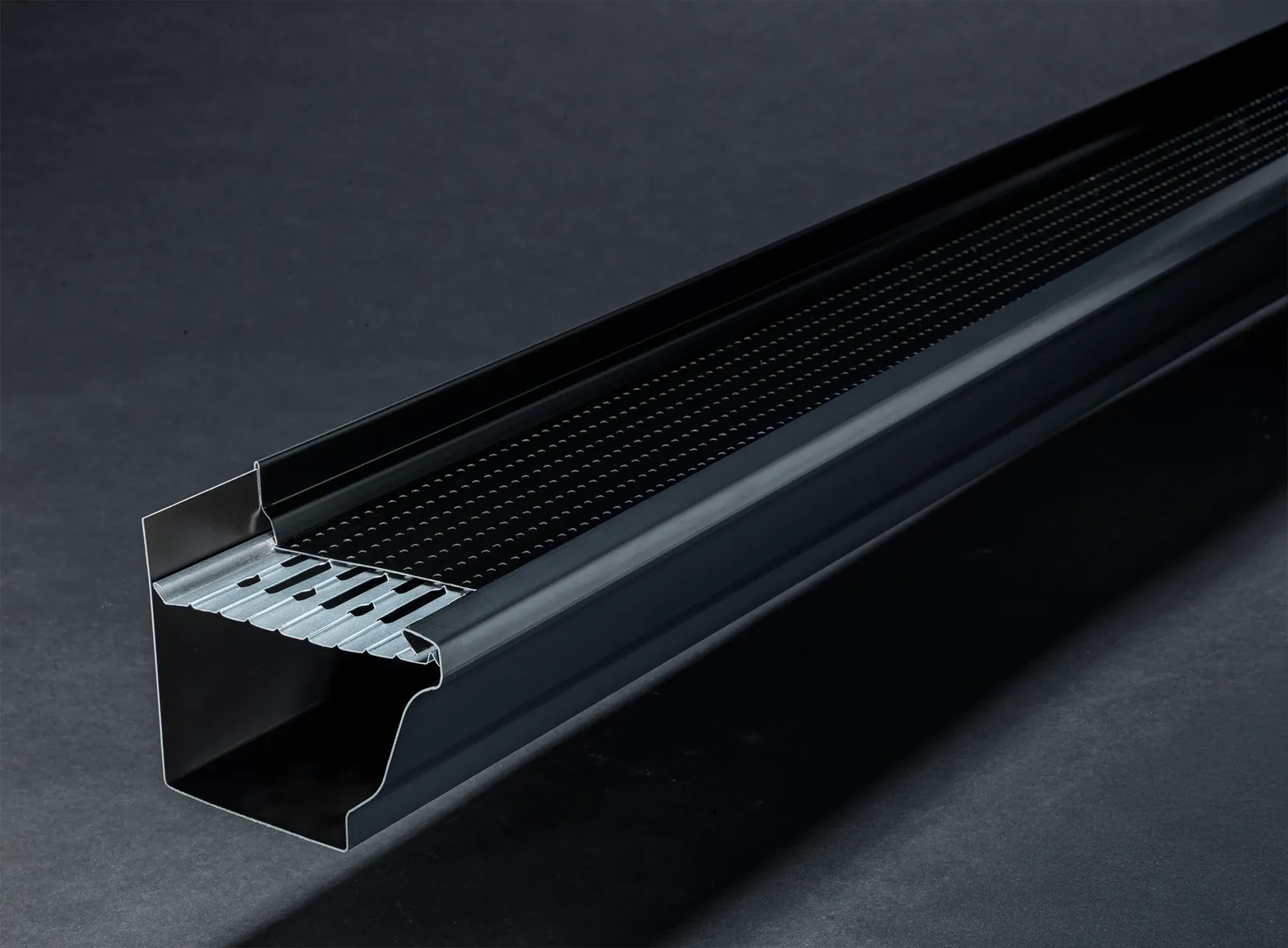 Black eavestrough fitted with an Alu-Rex gutter guard
