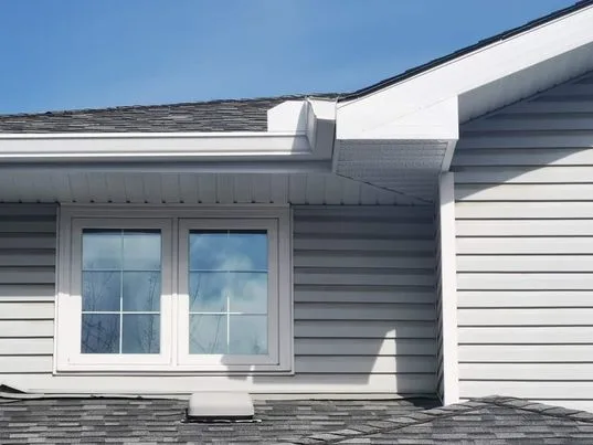White seamless eavestrough on a home with grey siding