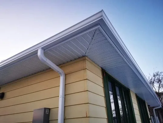 White eavestrough and soffit on a stucco bungalow